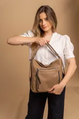 Cartera mochila color marrón de símil cuero suave con múltiples bolsillos con cierre, división al medio y correa ajustable de doble manija para llevar al hombro y como mochila.