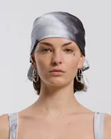 Pañuelo para la cabeza con estampado abstracto en tonos grises y negros.