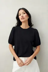 Remera negra de algodón con mangas abullonadas y elástico en la terminación.