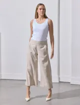 Pantalón crop de lino estampado con hojas en tonos verdes y azules. Tiene pretina trasera elastizada y bolsillos delanteros.