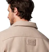 Camisa tipo chaqueta color beige, de corte recto, con cuello clásico, cierre frontal con botones y dos bolsillos de parche en el pecho. Tiene un anillo en D en el bolsillo izquierdo. Marca Columbia.