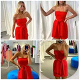 Vestido corto strapless color rojo, con espalda descubierta y detalle de moño en la parte delantera.
