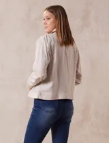 Campera de lino color beige, marca Dash, con abertura central y botones. Tiene bolsillos aplicados en la parte delantera.