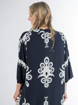 Vestido midi oversized con estampado en fondo negro, cuello tipo camisa, escote en V y tajos laterales.