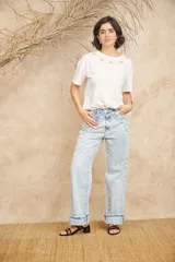 Pantalón de jean celeste de corte ancho con apliques bordados y desflecados.