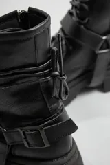 Borcegos negros de ecocuero con cordones y hebilla lateral.