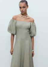 Vestido midi verde oliva de lino, con escote off-shoulder y mangas cortas abullonadas. Tiene corte evasé y cierre de cremallera en la espalda.