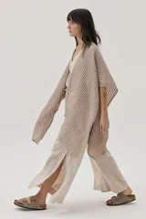 Ruana beige de tejido de punto acanalado con mangas cortas.