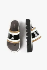 Sandalia con base alta, capellada ancha con acabado brillante y estructura acolchada. Suela dentada.