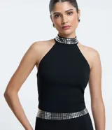 Blusa cropped negra de bengalina, con escote halter con lentejuelas y cierre en la espalda.