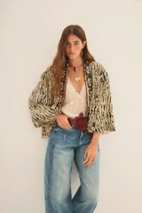 Kimono de manga ancha, estilo japonés, con estampado que imita piel de cebra en tonos beige y negro. El borde está decorado con apliques de mostacillas y bordados florales en tonos rojizos, verdes y dorados.