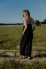 Conjunto de top y pantalón color beige. El top es de breteles anchos, con detalle en dos colores y un bordado en su delantera. El pantalón es liso, de corte recto ancho con bolsillos a los costados y cintura con botones y elástico.