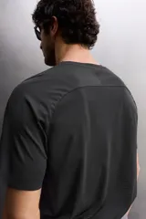 Camiseta deportiva negra de tejido técnico ligero con perforaciones, cuello redondo y manga corta.