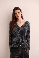 Sweater negro con estampado de tigres y árboles en blanco, cuello en V y mangas largas.