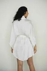 Bata corta color blanco de seda suave con mangas anchas y lazo para atar en la cintura.