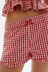 Short de algodón con estampado de cuadros vichy rojos y blancos, cintura elástica con moña de satén y ribete de volados en el bajo.