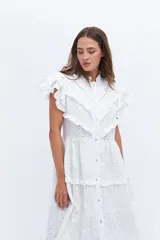 Vestido midi blanco de lino, con cuello mao, botones frontales y volados en las mangas cortas. Presenta un diseño escalonado con volados en los ruedos de los paneles.