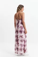 Vestido largo con estampado difuminado en tonos borgoña y blanco, breteles finos regulables y espalda con tiras entrecruzadas. Tiene escote en “V” y tajos laterales.