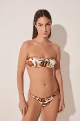 Conjunto de bikini con estampado de peces color naranja y negro sobre fondo blanco. El corpiño es bandeau y la bombacha es de corte clásico.