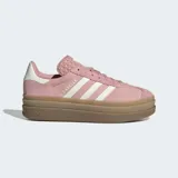 Championes Adidas Gazelle Bold de mujer, color rosa palo con tres franjas laterales blancas y logo 'GAZELLE' en dorado. Cuentan con una suela de plataforma gruesa color caramelo y detalles en blanco en el talón y la lengüeta.