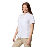 Camisa blanca de manga corta para mujer, marca Columbia, modelo Silver Ridge Utility. Confeccionada con materiales reciclados, ofrece protección solar UPF 50, absorción del sudor y ventilación. Cuenta con tapeta abotonada, bolsillos en el pecho con cierre a presión y velcro, y un pequeño bolsillo interior.