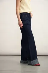 Pantalón de jean azul oscuro, de corte acampanado y tiro alto.