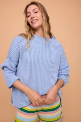 Buzo color crema tejido en algodón, de silueta holgada, mangas anchas y cuello bote.