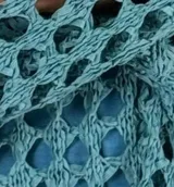 Top tejido crochet color beige, con escote en V y mangas largas acampanadas.