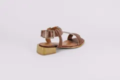 Sandalias de cuero doradas con tiras finas, suela plana y hebilla lateral.