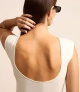 Blusa sin mangas color blanco, con cuello redondo y espalda abierta con escote en U.