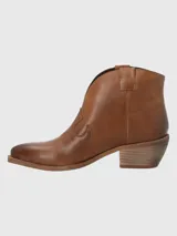 Botín de cuero metalizado color peltre, con puntera fina, laterales con diseño estilo cowboy y taco bajo.