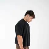 Remera negra de algodón, corte cuadrado y holgado, estilo boxy fit, cuello redondo y mangas cortas.