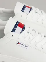 Zapatillas Tommy Jeans Essential de cuero blanco, con cordones y suela cupsole de goma. Presentan el logo de Tommy Jeans en la lengüeta y en el talón.