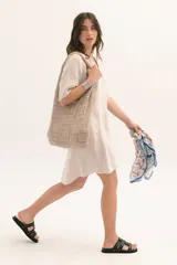 Vestido corto color arena, de lino, con escote en V y mangas cortas.