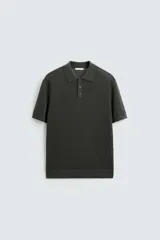 Polo de punto color verde oscuro, con cuello solapa y cierre frontal de botonadura.