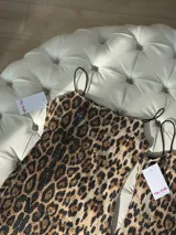 Vestido corto con estampado animal print y lentejuelas transparentes, de tirantes finos y forro interno.