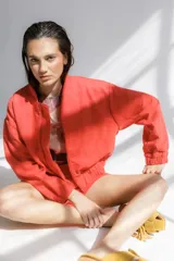 Bomber color coral confeccionada en mezcla de algodón y lino, con cierre frontal y puños elásticos. Presenta un bordado grande en la espalda inspirado en la colección La Verdulería.