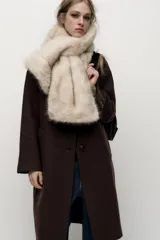 Bufanda de pelo sintético color beige con diseño cruzado.