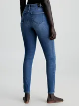 Jeans de denim azul medio vintage, corte skinny, tiro medio, cinco bolsillos y cierre con cremallera.