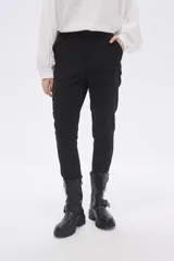 Pantalón negro de vestir, corte slim fit y largo al tobillo.