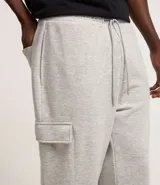 Pantalón baggy negro de algodón y poliéster, con cintura elástica ajustable con cordón, bolsillos laterales tipo cargo y bolsillo trasero.