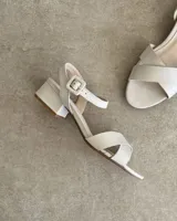 Sandalias bajas negras con tiras finas cruzadas y tobillera con hebilla.