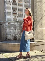 Blusa color terracota de muselina con escote en V y lazos para ajustar. Tiene mangas largas abullonadas con volados en los puños.