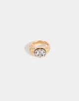 Anillo dorado de sello con diseño vintage y una flor grabada en el centro.