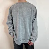 Buzo celeste con efecto gastado, corte oversize, cuello redondo y puños y ruedo acanalados.