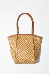 Bolso tote de cuero trenzado en tonos marrón y negro, con asas de cuero trenzado color bordó.