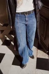 Pantalón de jean gris oscuro de corte recto, tiro medio y largo. Diseño con costuras verticales y lavado con sobreteñido.