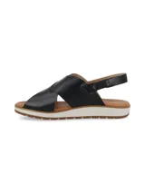 Sandalias negras con tiras cruzadas de cuero y suela blanca.