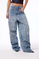 Pantalón de jean oversized de tiro bajo, color azul lavado, con estampado de tigresa grabado con láser.