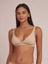 Sostén tipo halter de algodón color beige, con escote en V y bordes festoneados.